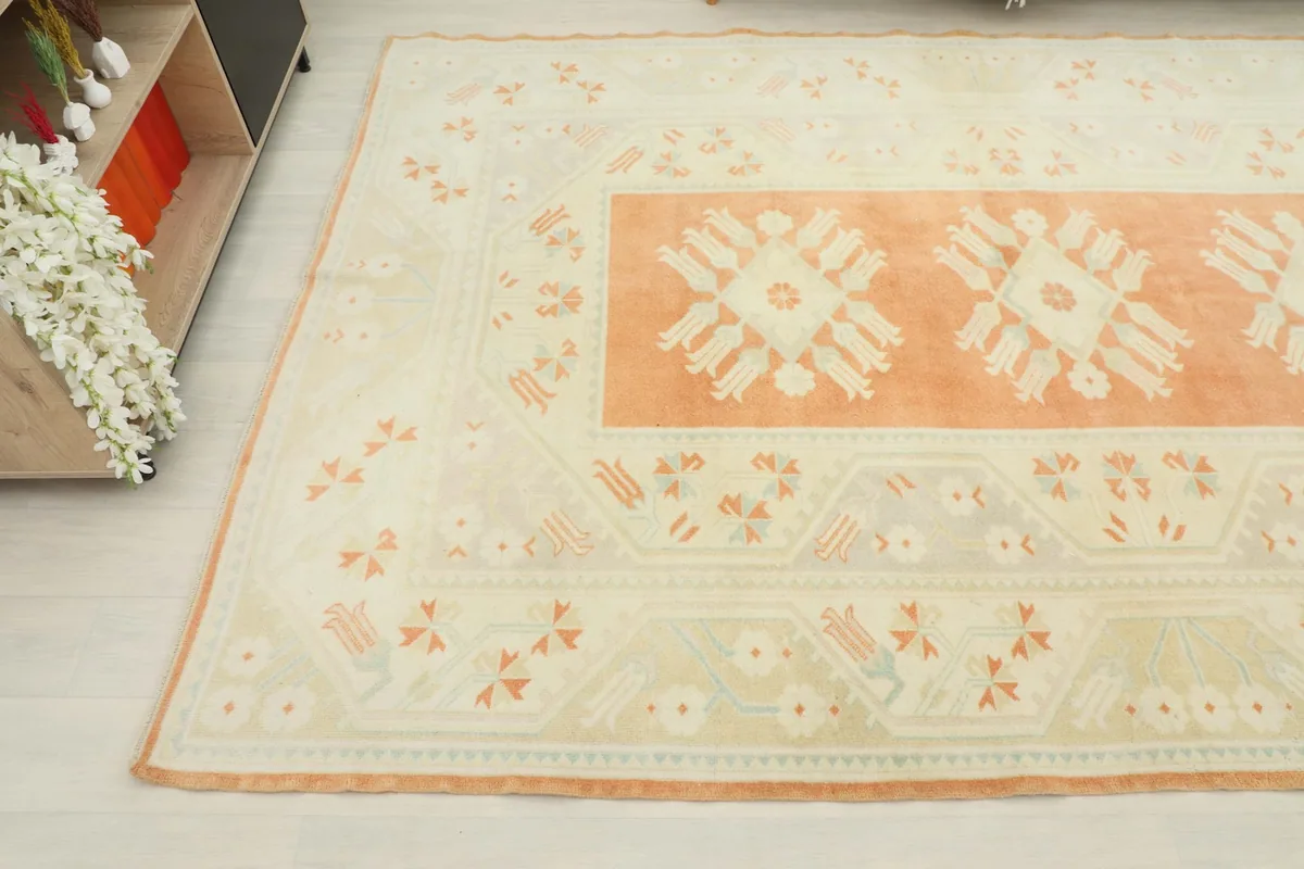 Angled view of the rug's surface, capturing the subtle variations in the rust and cream tones.