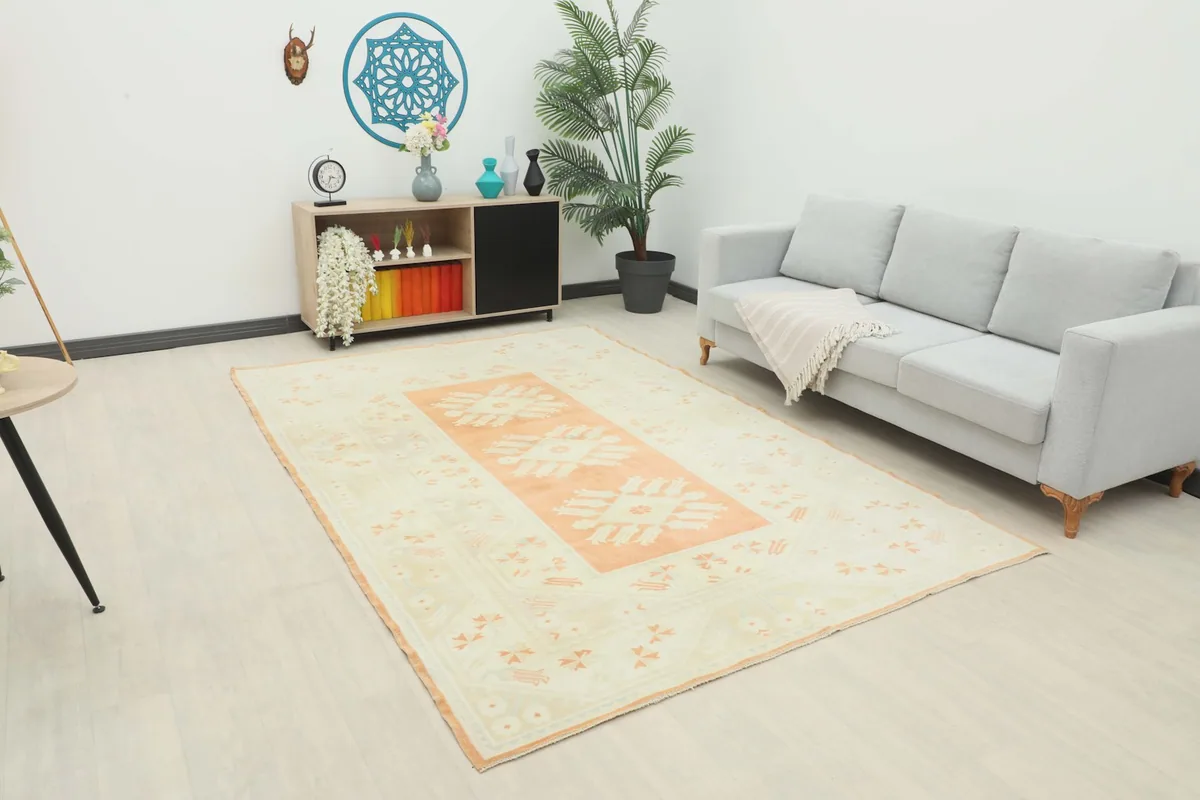 Vintage Anatolian rug placed in a modern living room setting, showing its scale next to a sofa.