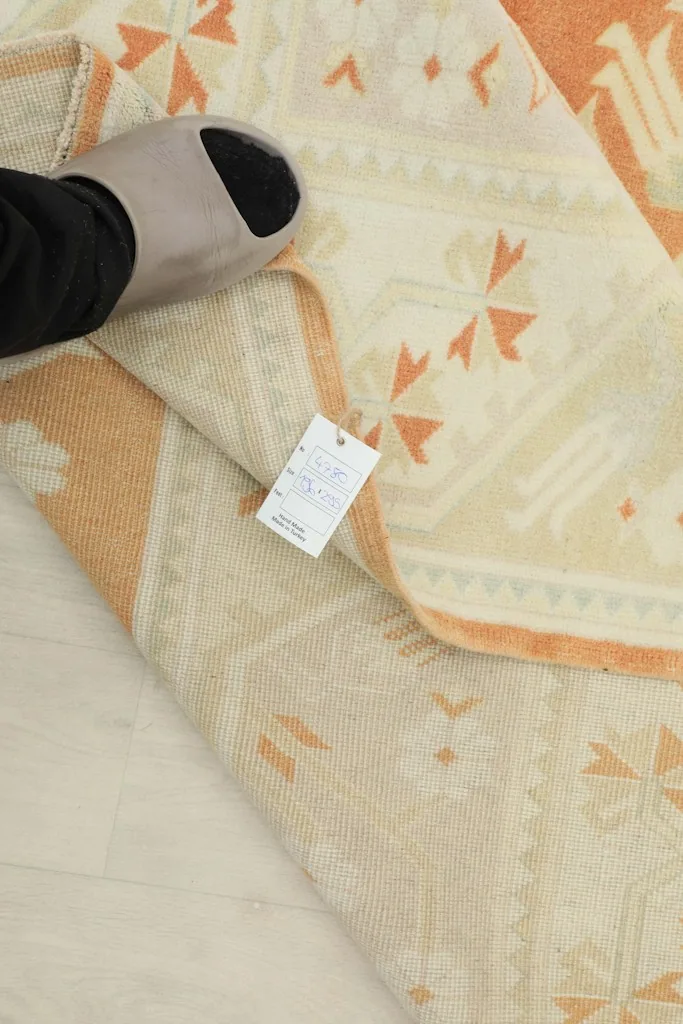 Close-up of the rug's underside and tag, showing the tightly woven cotton foundation.