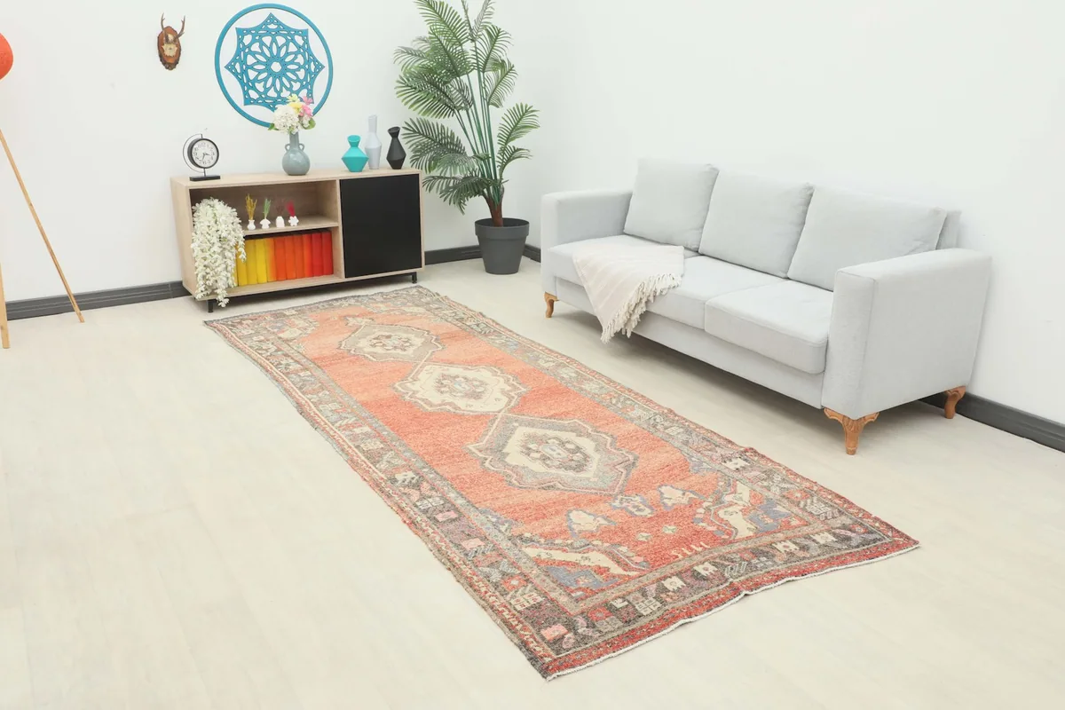 The rust runner rug placed in a modern living space with a white sofa and light-colored flooring.