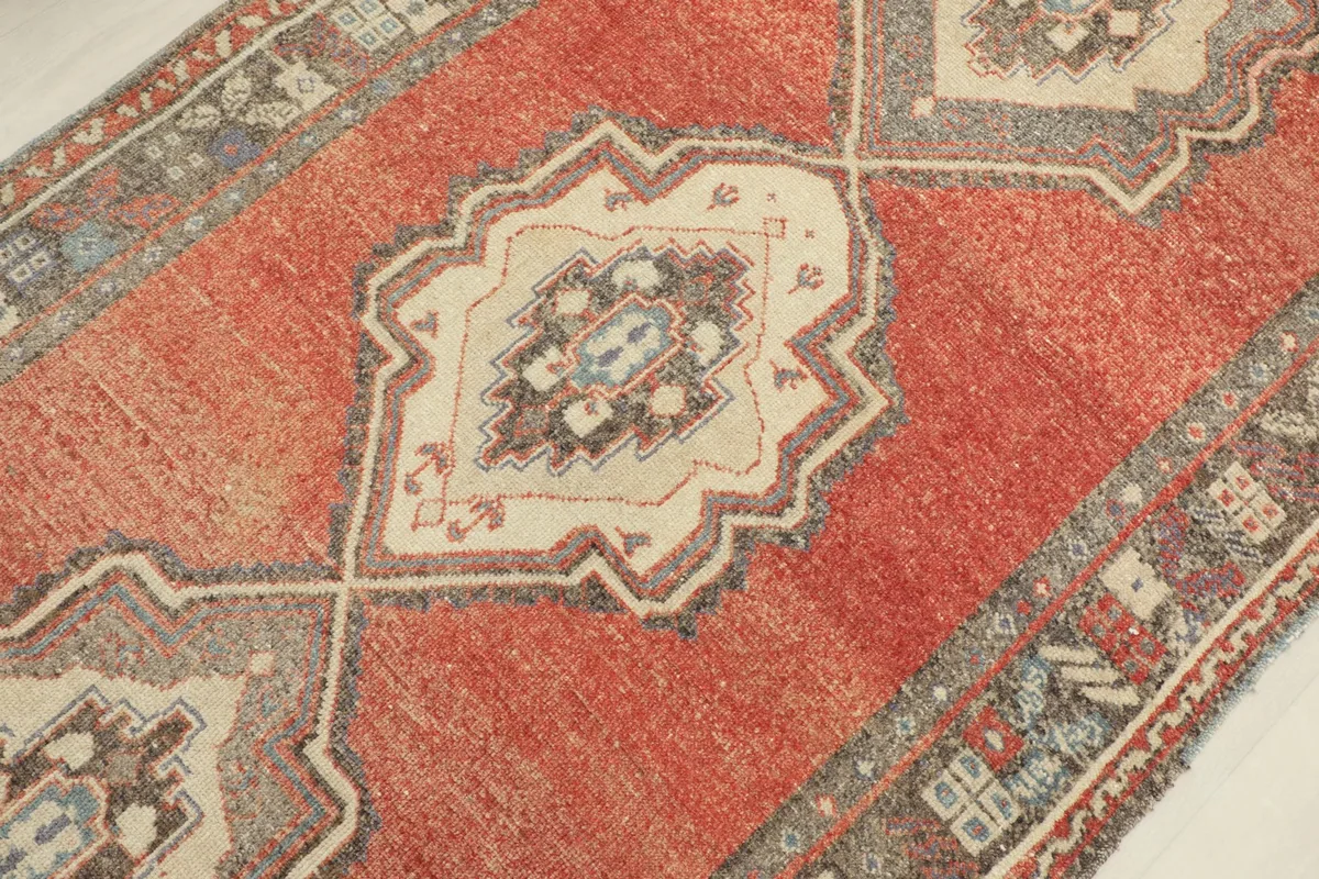 Detailed view of one of the central geometric medallions in beige, gray, and blue tones.