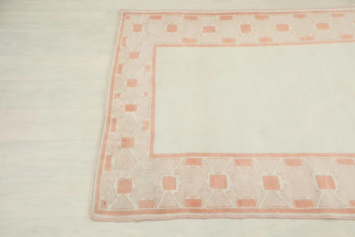 Corner detail of the ivory field and rose geometric patterns on the Anatolian rug
