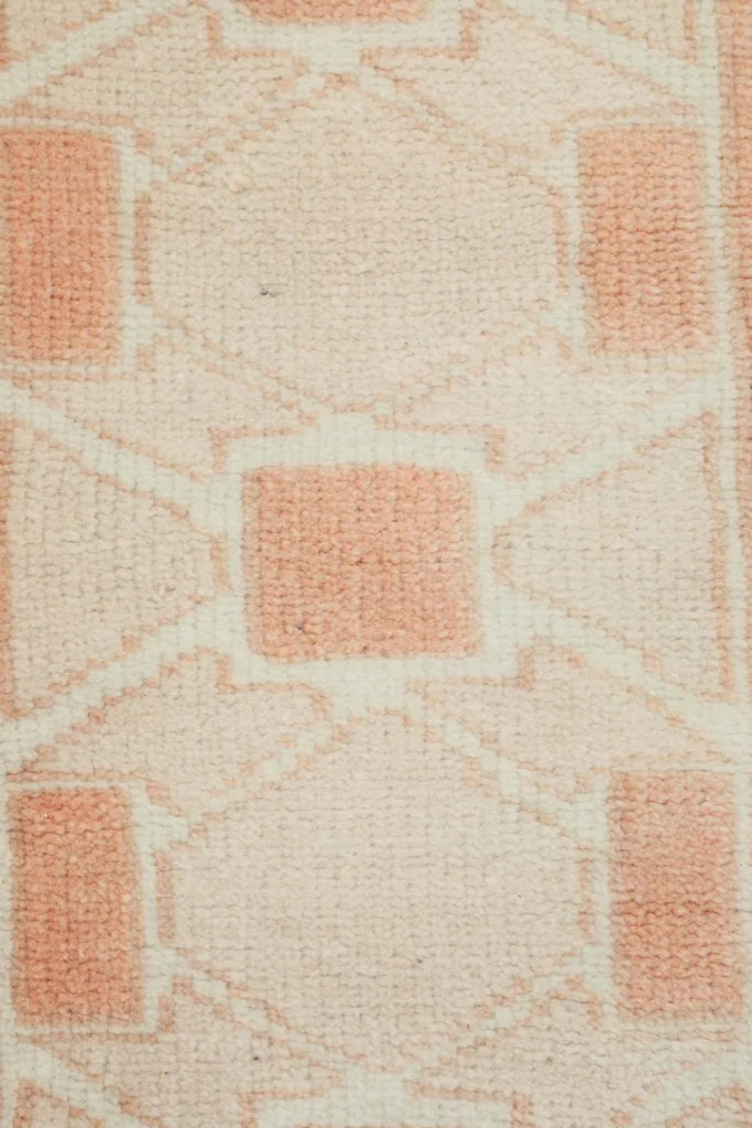 Texture close-up of the low wool pile and hand-knotted rose geometric design