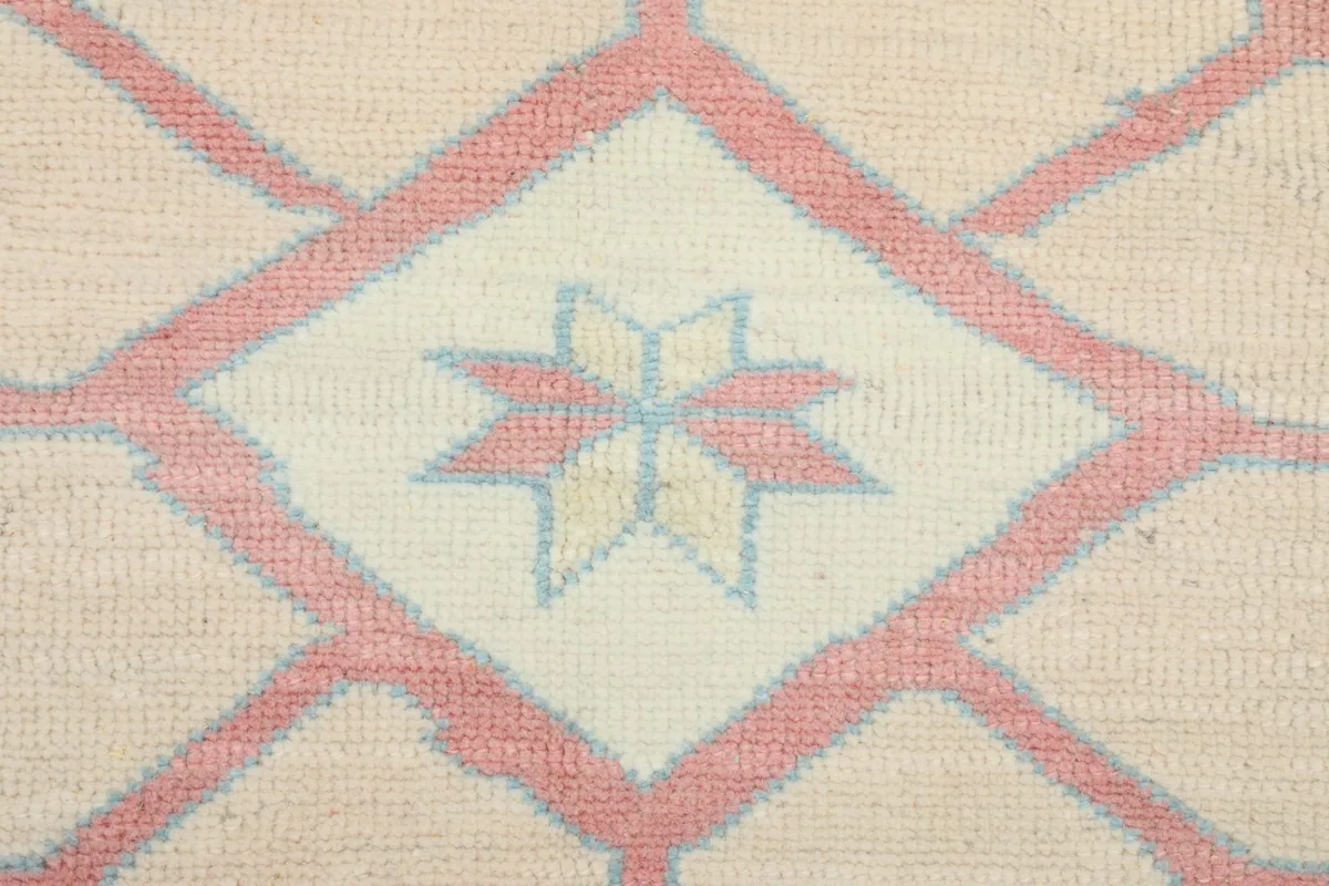 Detailed view of the hand-knotted wool pile, showing texture and colors of the central motif