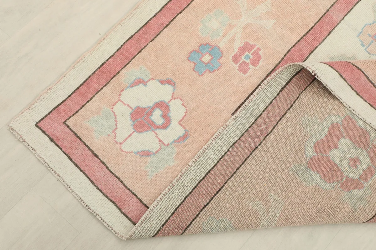 Corner of the rug folded back, revealing the reverse side and construction