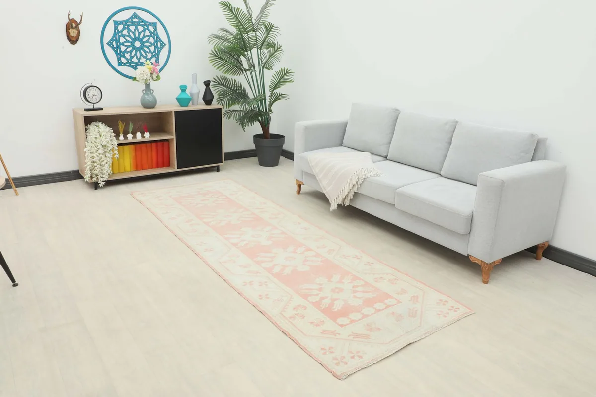 Runner rug placed in a living room scene with a gray sofa and light wood floor