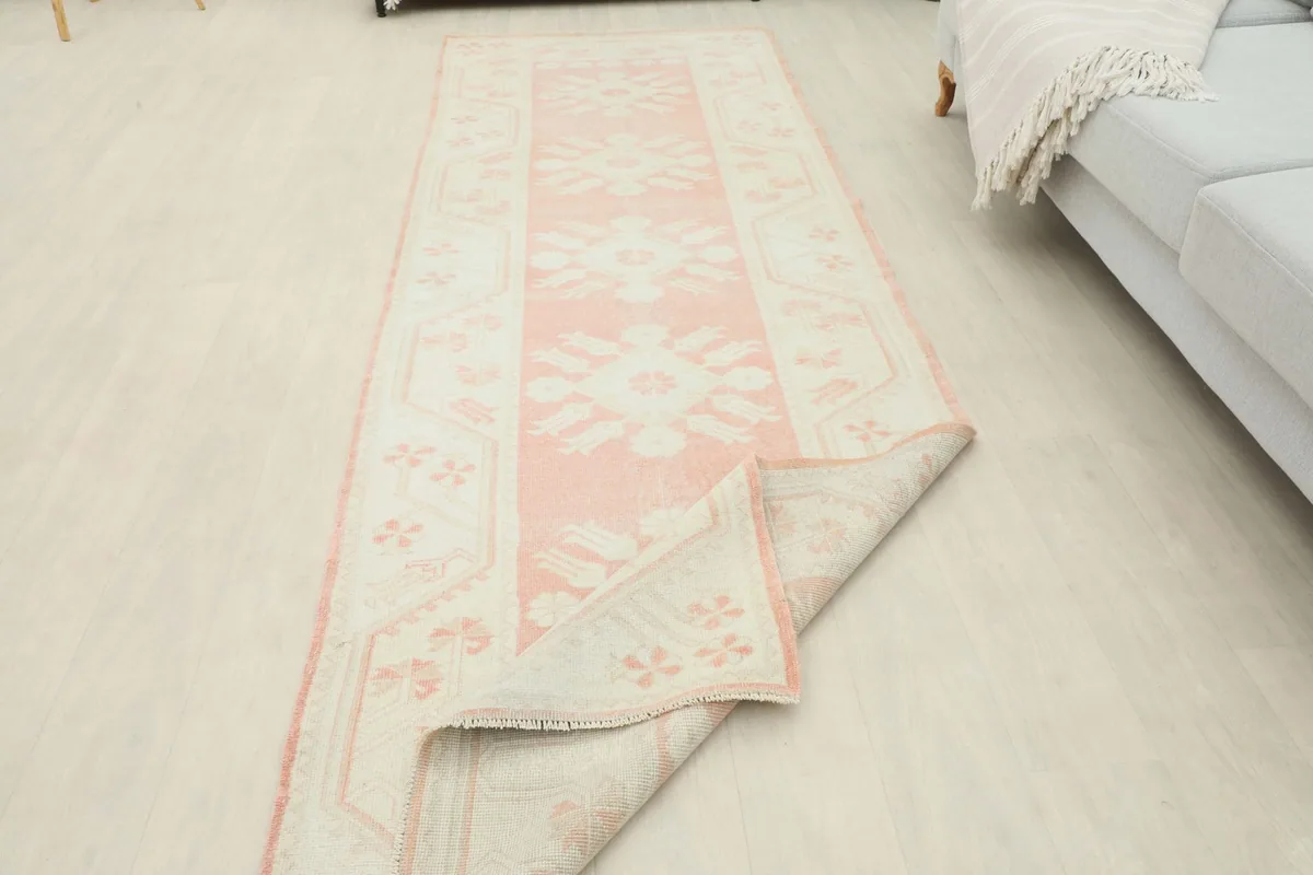View of the runner with one corner folded back, revealing the reverse side and cotton foundation
