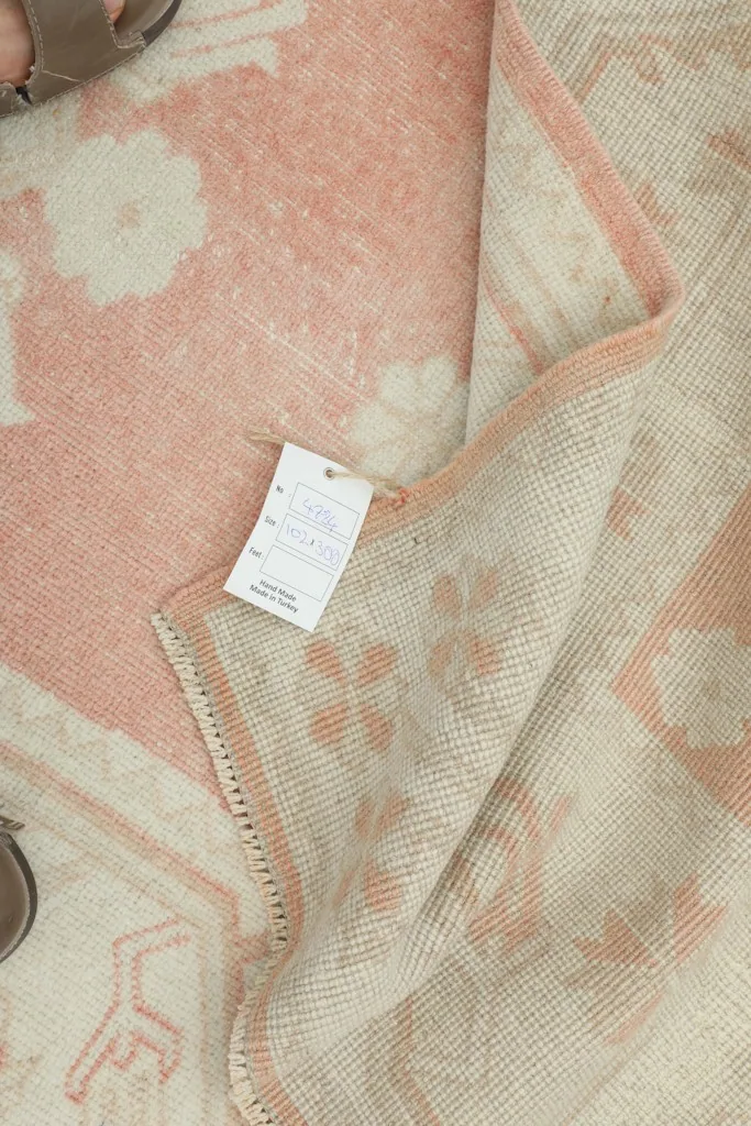 Close-up of the care tag attached to the back of the vintage hand-knotted wool runner