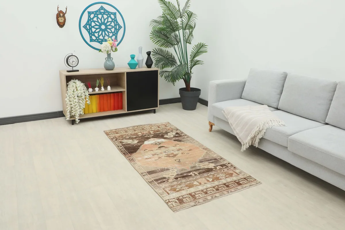Rust and brown vintage rug placed in a modern living room setting with a light gray sofa