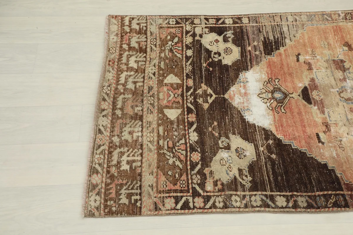 Close-up of the upper left section of the rug, highlighting tribal motifs and color variations