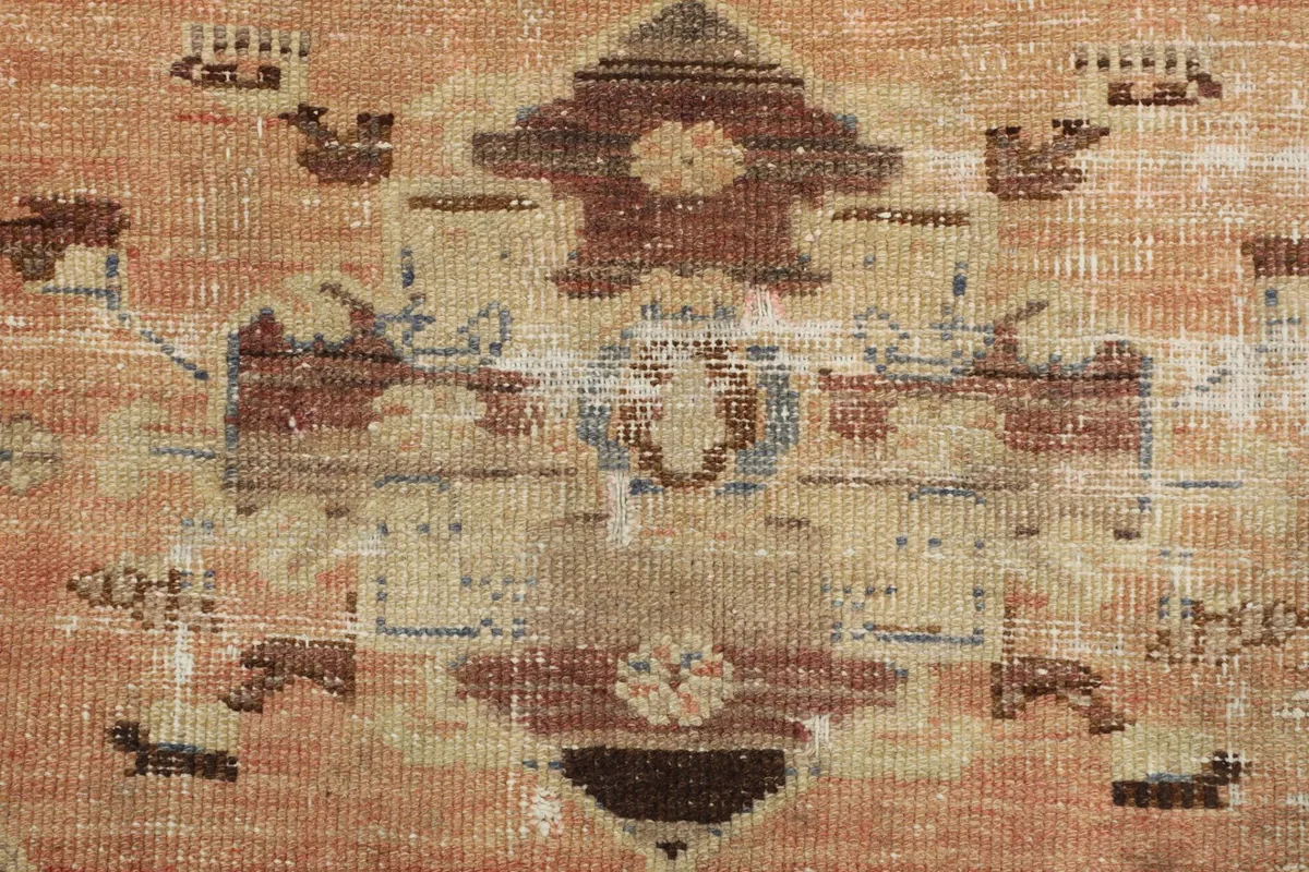 Extreme close-up of the medallion's center, revealing the hand-knotted texture and colors