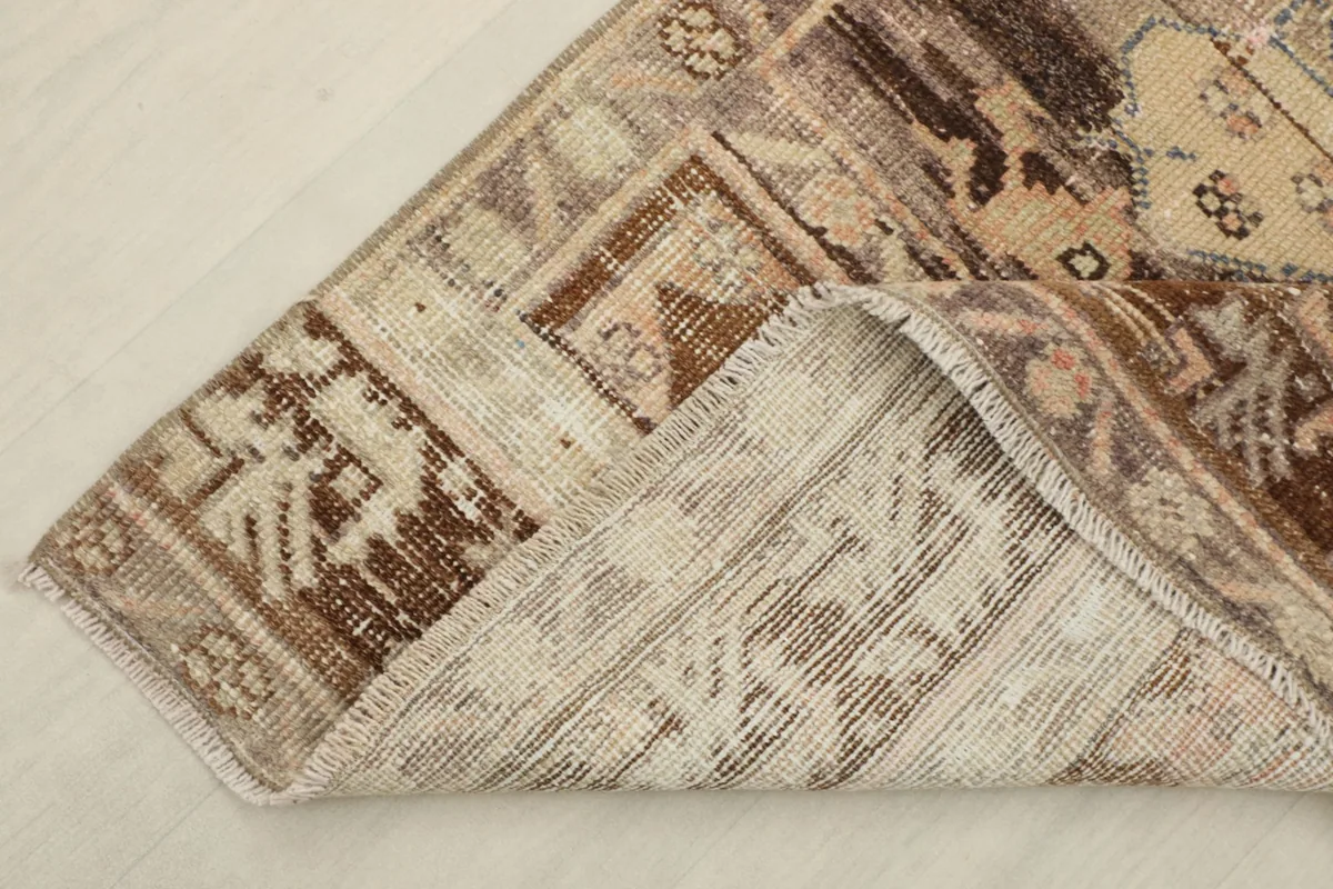Corner of the rug folded back to show the cotton foundation and the reverse side of the knots