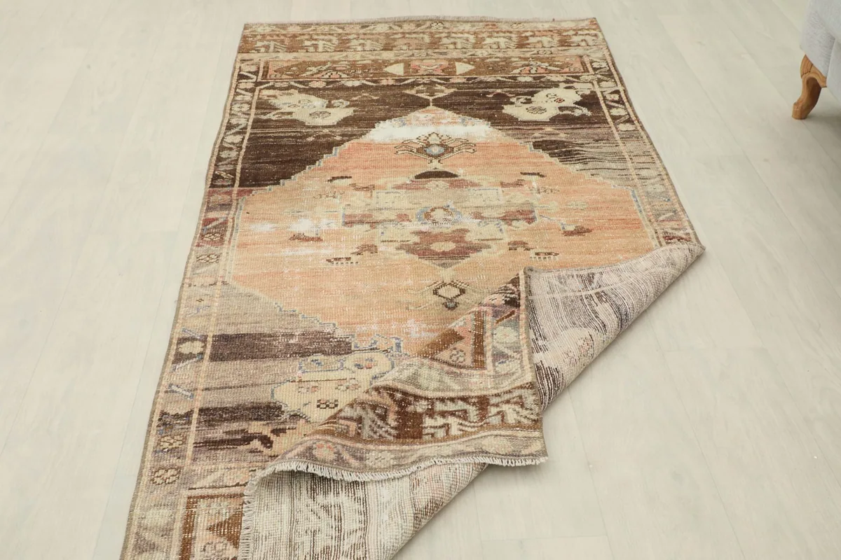 Rug with one end folded over, displaying the backside and the texture of the wool pile