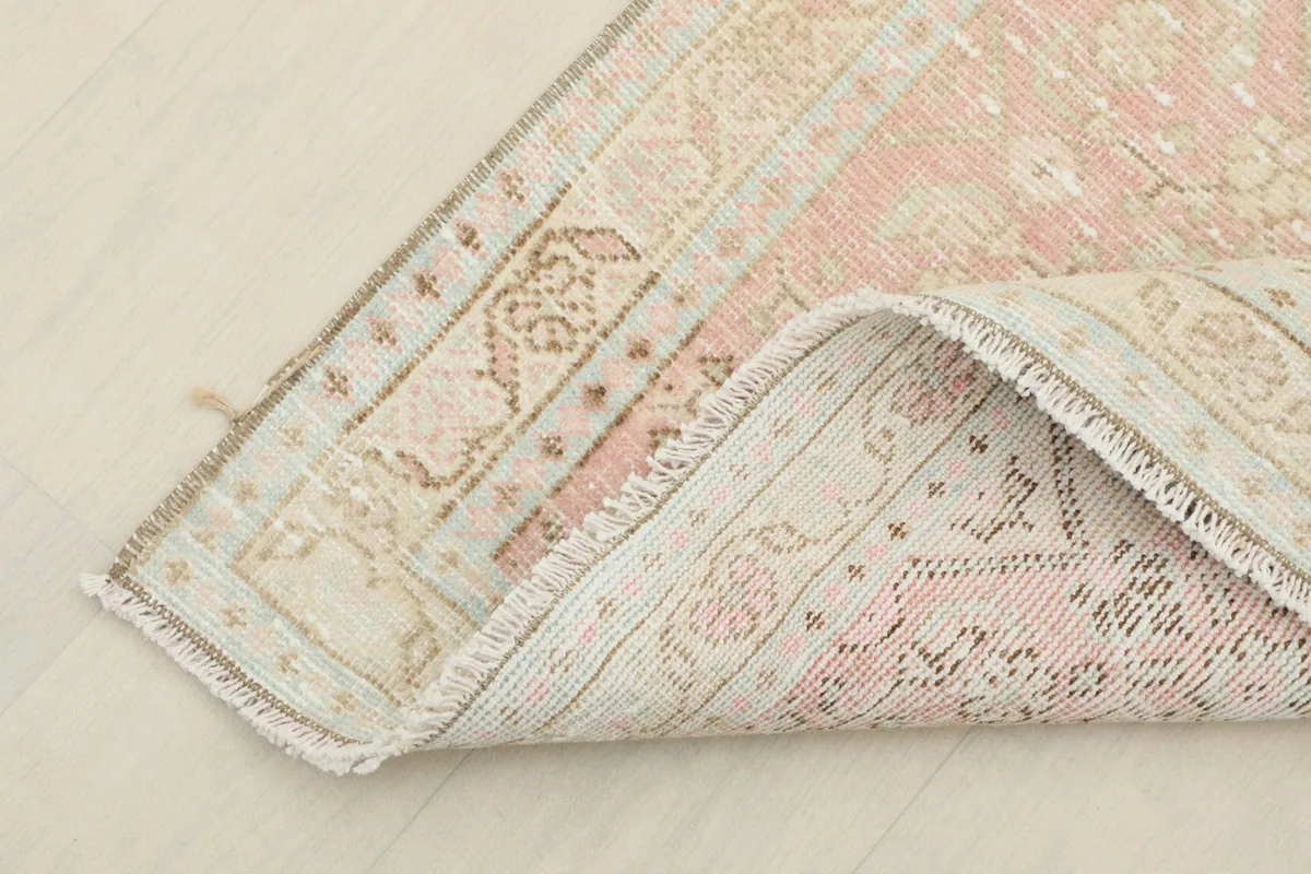 The runner rug folded to show the back of the hand-knotted cotton foundation and wool pile.