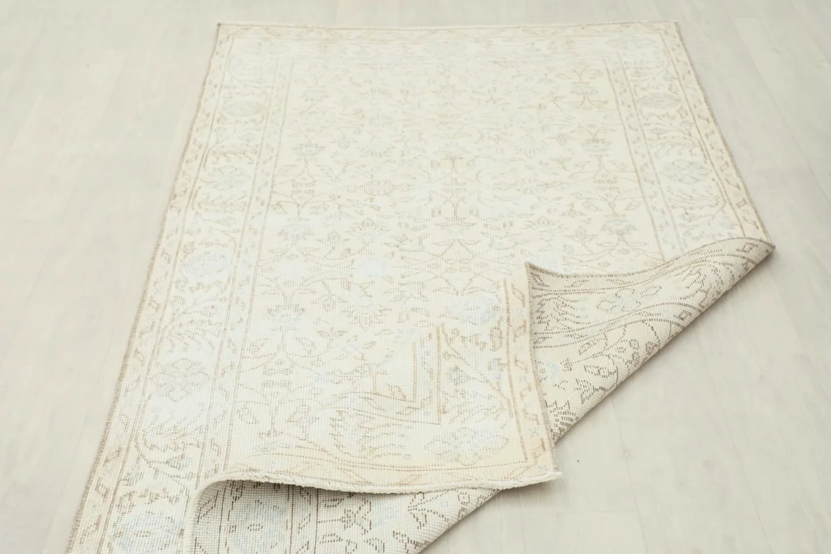 Rug partially folded to show the flexibility and thickness of the vintage wool pile