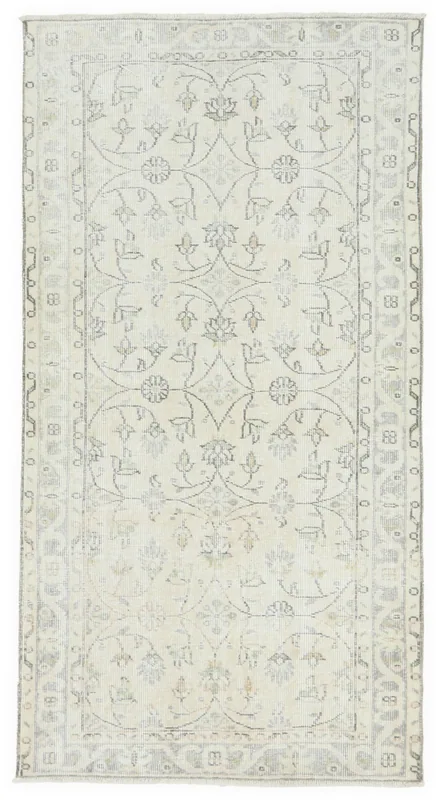 Full top view of the 3'5" x 6'4" ivory floral vintage Anatolian rug on a white background