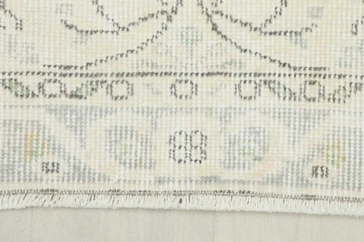 Detail of the rug's fringe and the tightly woven cotton foundation visible from the back