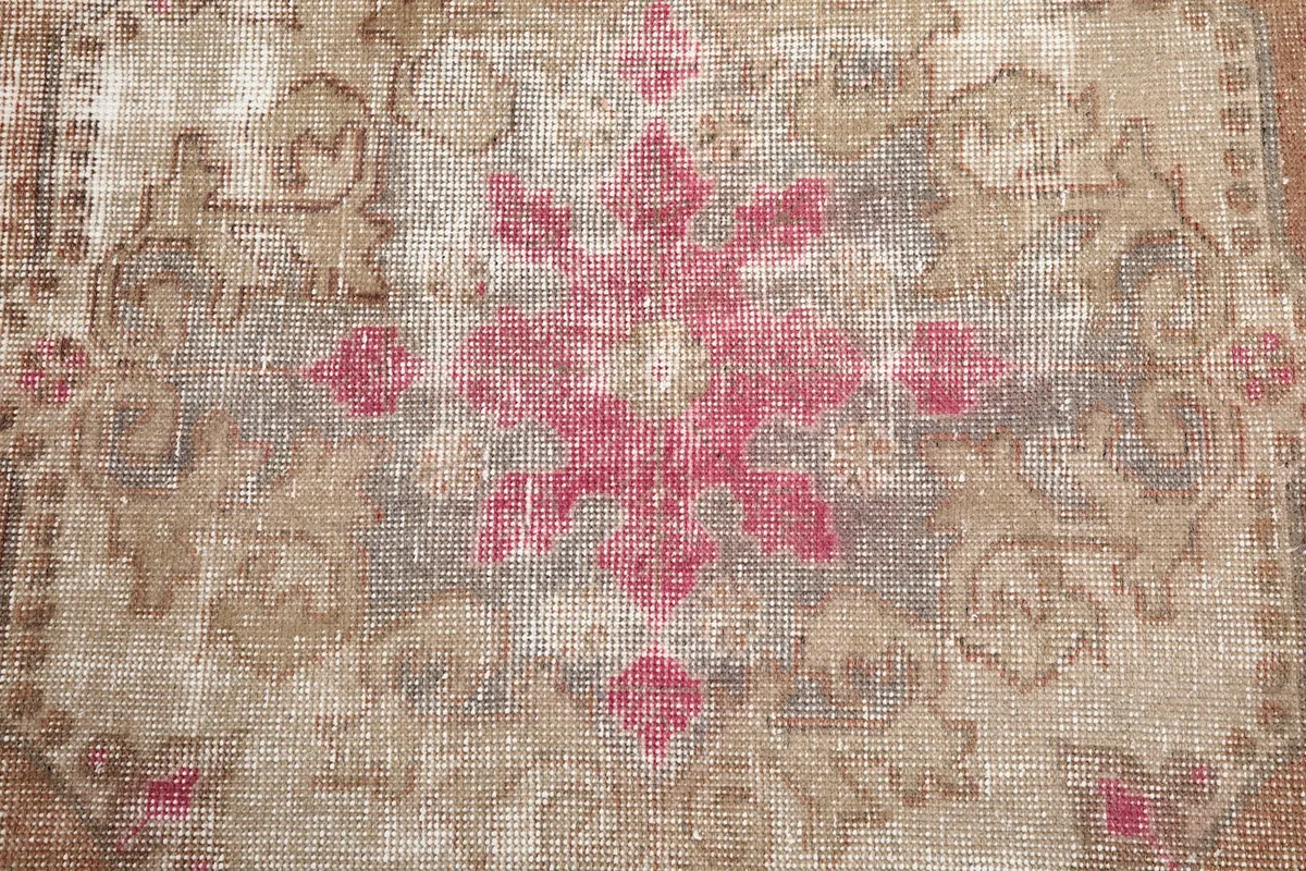 Close-up of the distressed rose and gray motifs in the center of the rug
