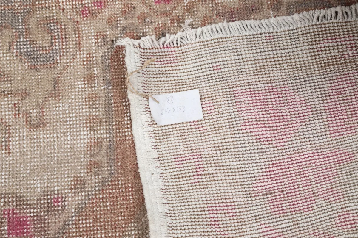 Detail of the rug's fringe and a small label on the back