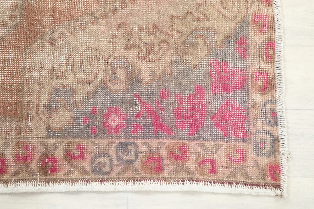 Detail of the rug's border with rose and gray floral-geometric designs