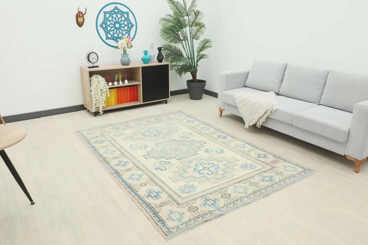 Vintage ivory and blue rug displayed in a modern living room setting with a light gray sofa.