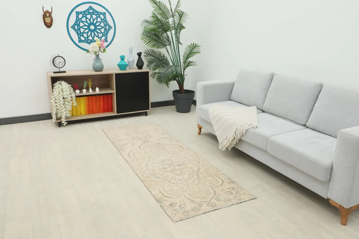 Ivory and gray runner rug placed in a living room setting, showcasing its length and scale.