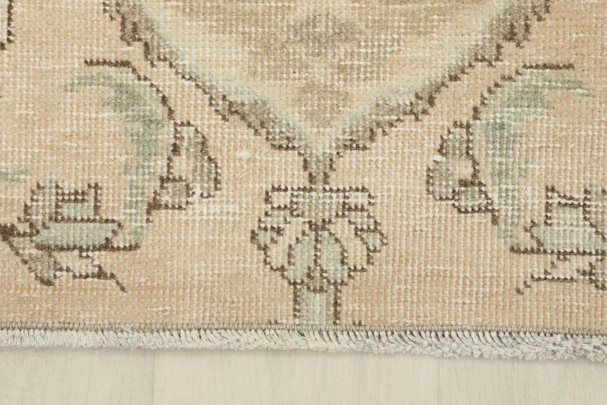 Close-up of the rug's short fringe and the edge where the pile meets the foundation.