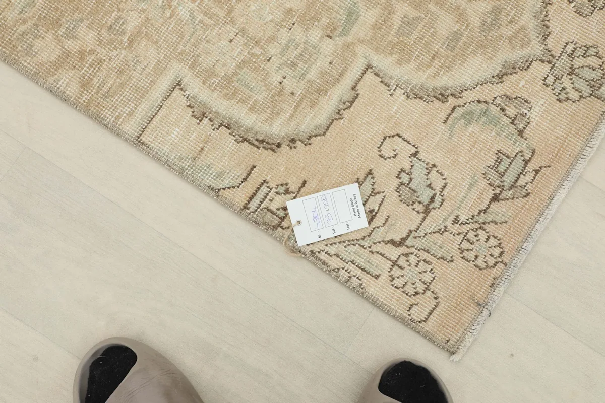 Overhead view of a section of the rug, with a measurement card for scale next to the pattern.