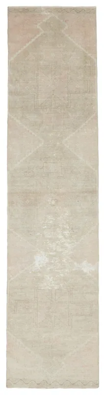 Full overhead view of the beige and rose vintage Anatolian runner rug on a white background.