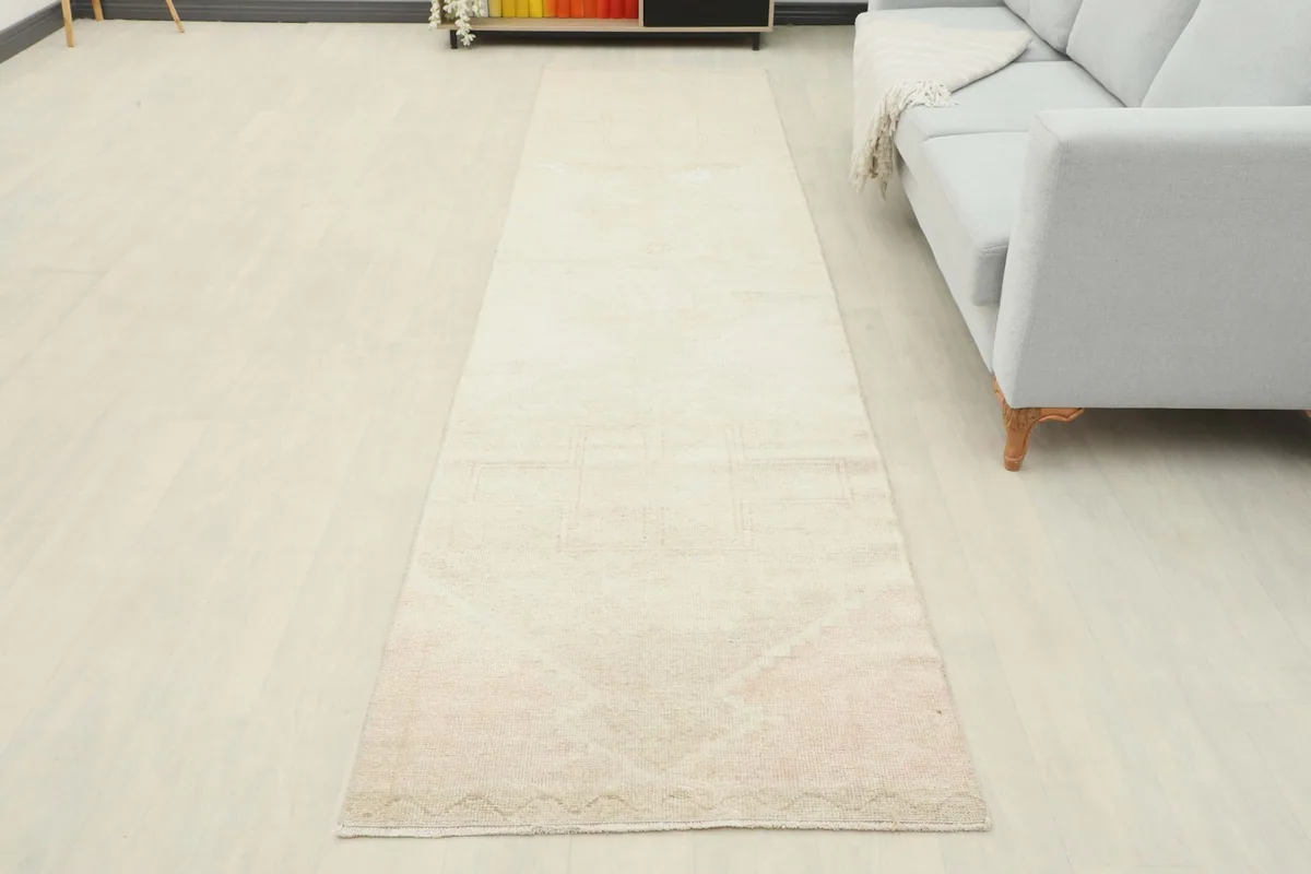 Full room view of the beige runner rug laid out, providing a sense of its overall presence and length.