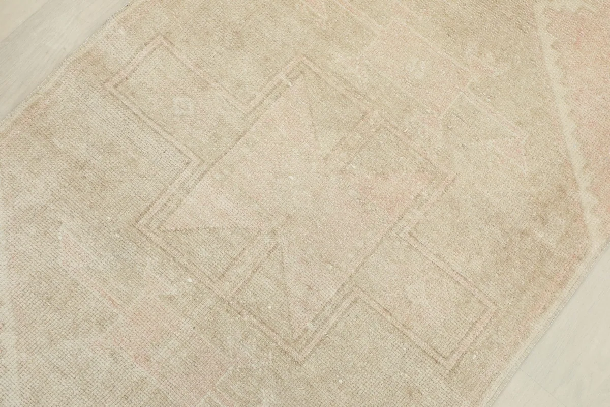 Detailed overhead shot focusing on the faded geometric pattern and texture of the rug pile.