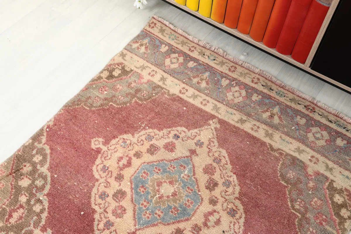Close-up of the rug's border with muted gray and beige floral motifs