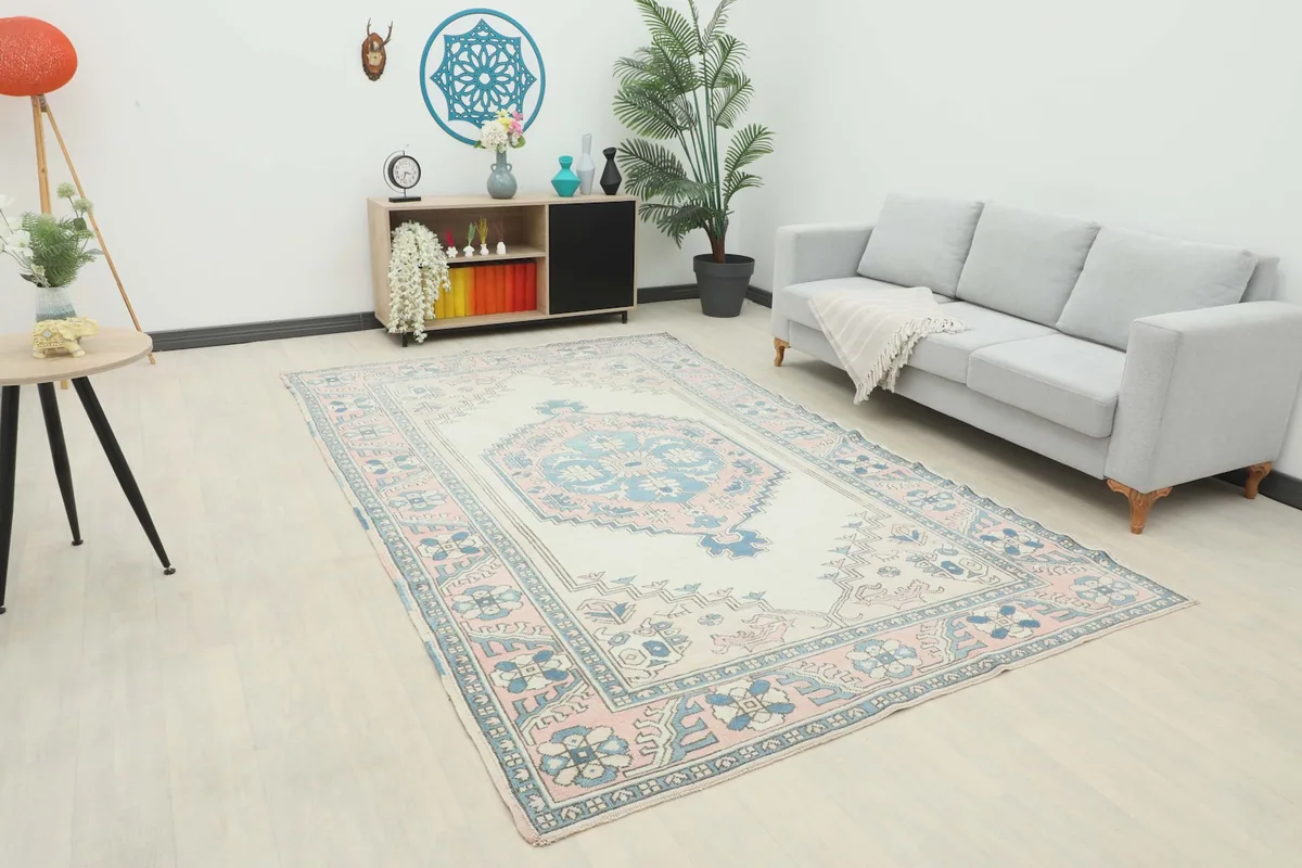 Vintage Anatolian rug displayed in a room setting with a light gray sofa and modern decor.