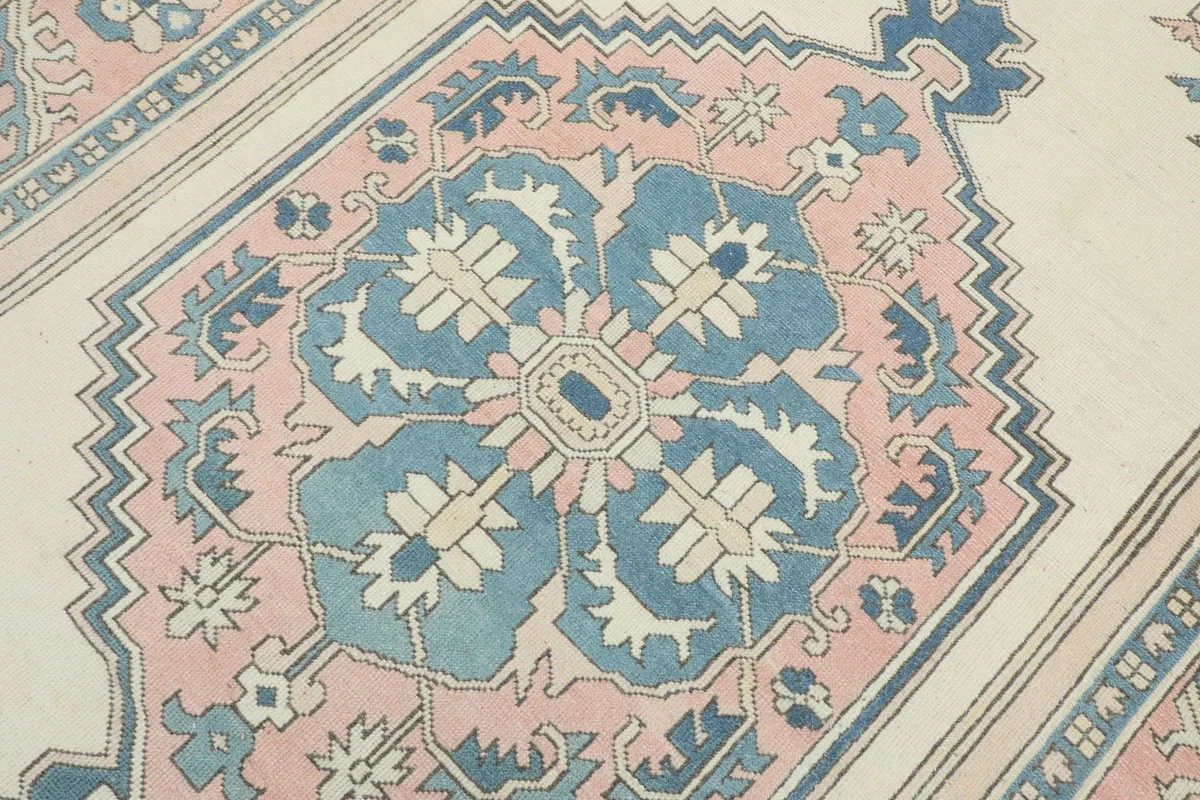 Detailed view of the central medallion, showcasing the blue and pink floral and geometric elements.