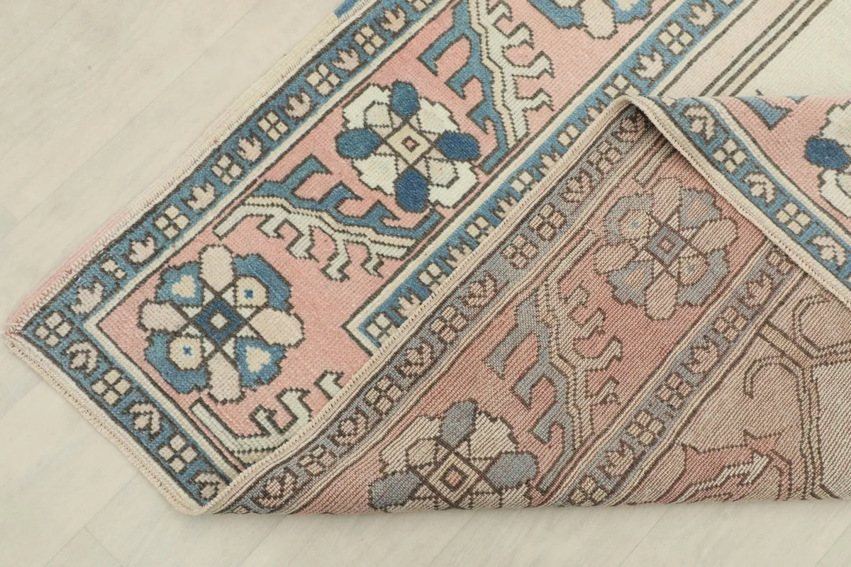 Corner of the rug folded back, showing the consistent pattern and the reverse side.