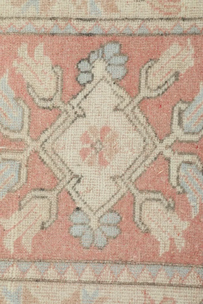 Tight close-up of a central motif within the rose field, highlighting blue and beige details