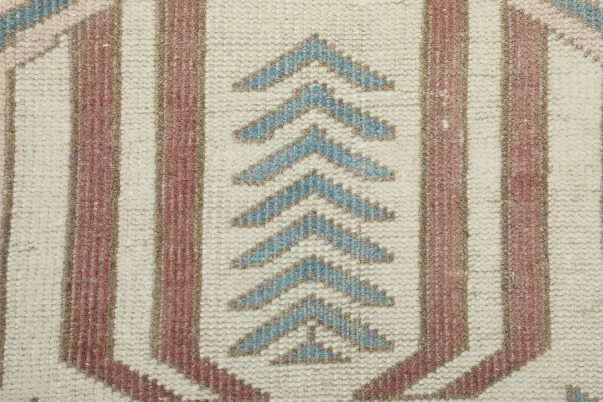 Detailed view of the hand-knotted wool pile and intricate arrowhead motif within a medallion.