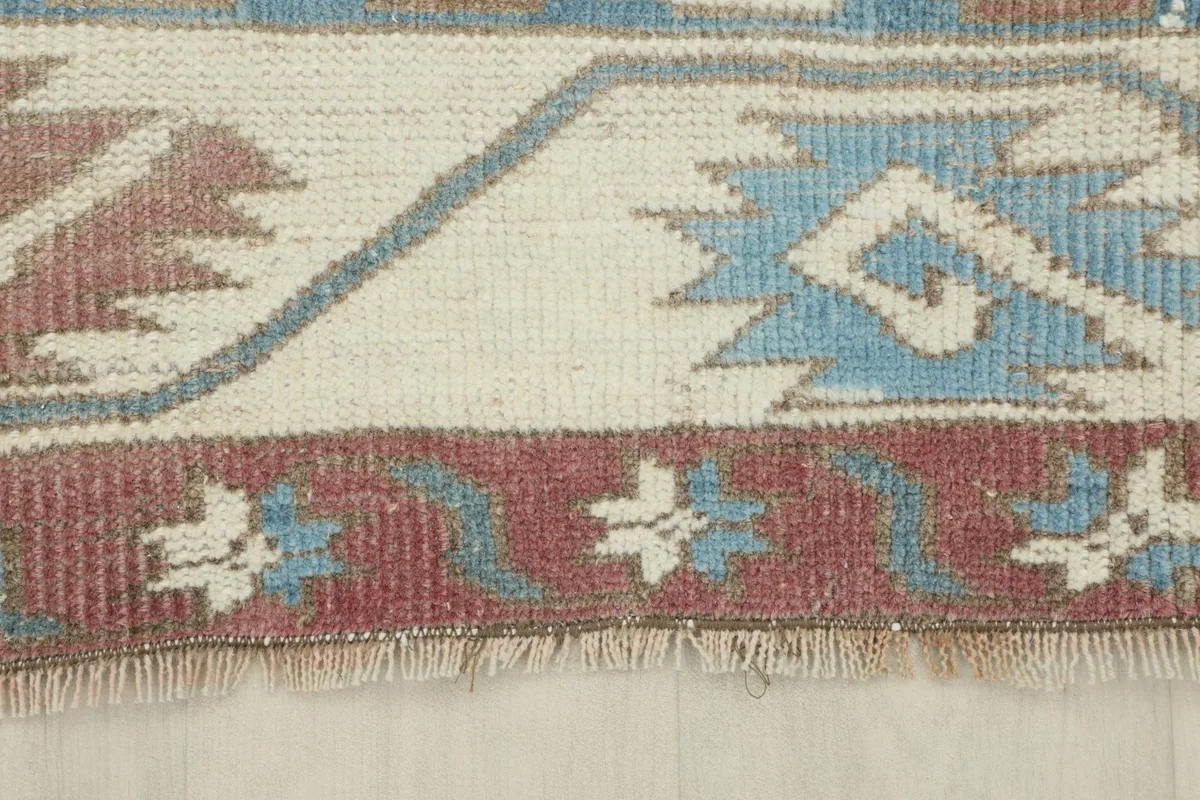 Detail of the rug's short fringe and the edge of the border design.