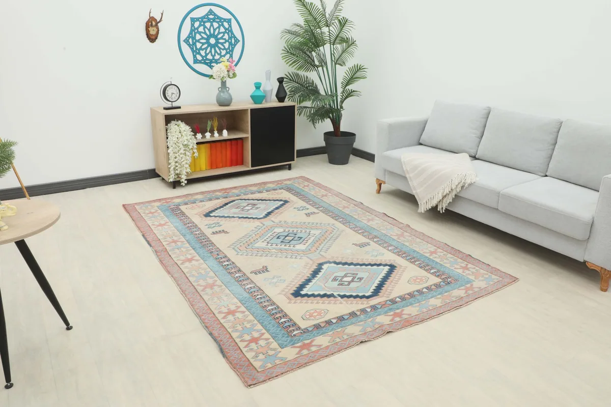 Vintage Anatolian rug displayed in a bright living room setting with a sofa and cabinet