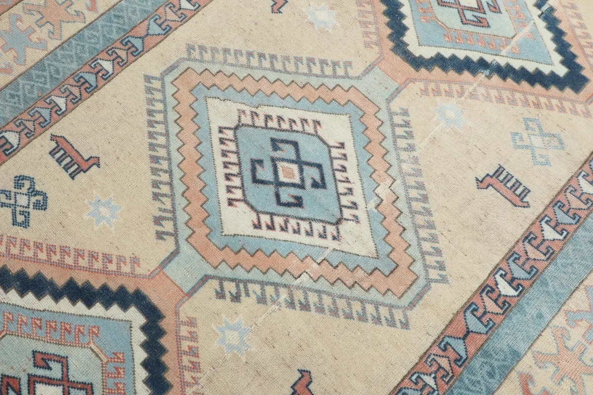 Detailed view of the central diamond motif in blue, navy, and beige with tribal symbols