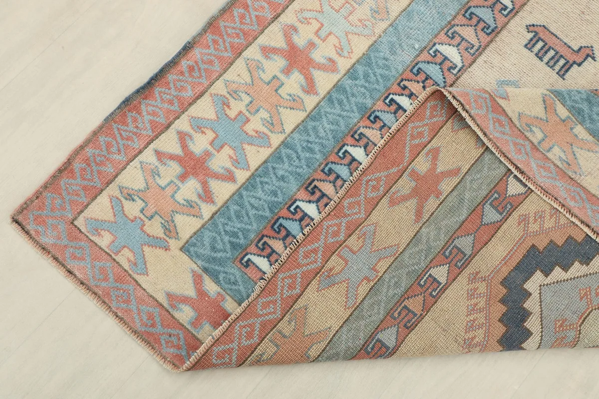 Corner of the rug folded to reveal the back, showing the hand-knotted cotton foundation