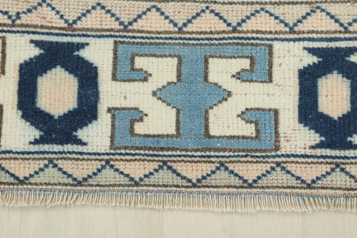Close-up of the geometric border design on the Cream Blue Geometric Anatolian Rug