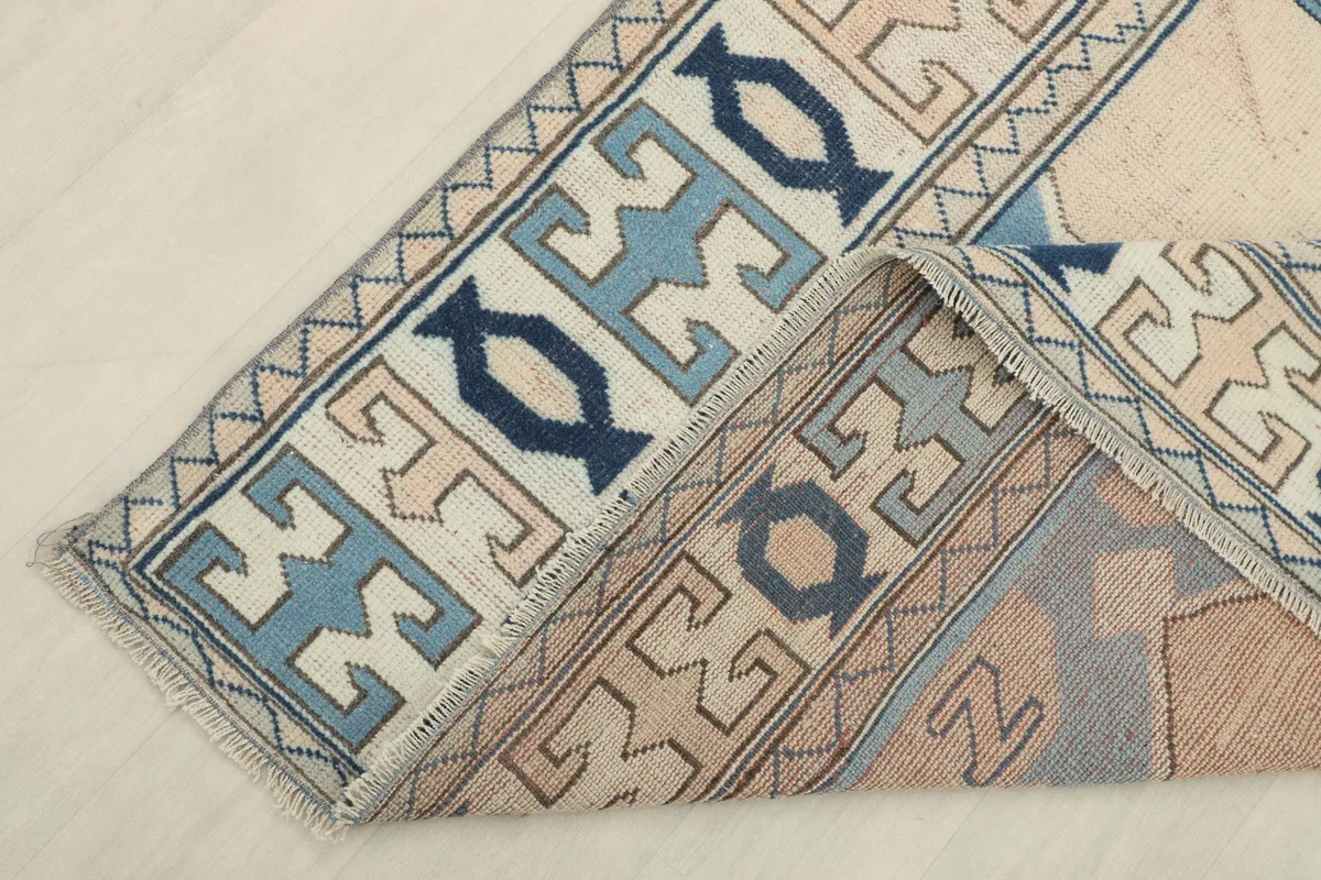 Cream Blue Geometric Anatolian Rug folded back to show the reverse side and hand-knotted construction