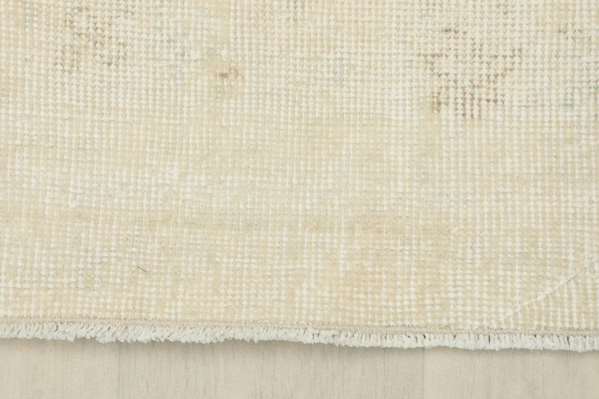 Detail of the rug's short, natural fringe and the tight weave of the cotton foundation.
