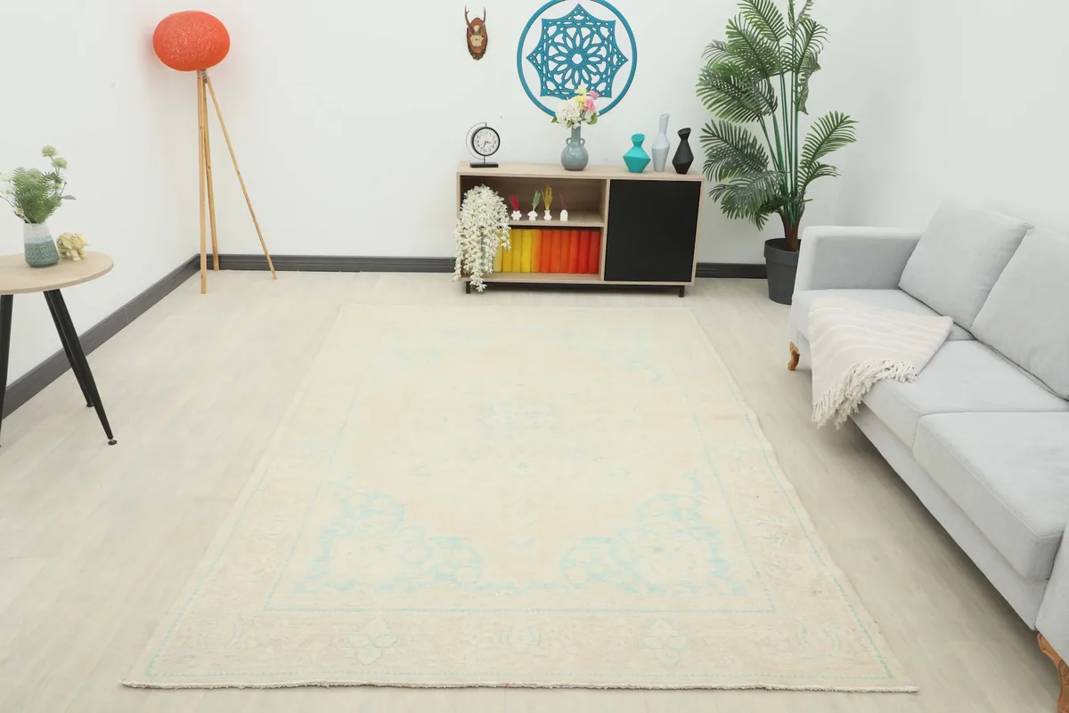 Wide shot of the vintage rug in a living space, providing a full perspective of its scale and design.