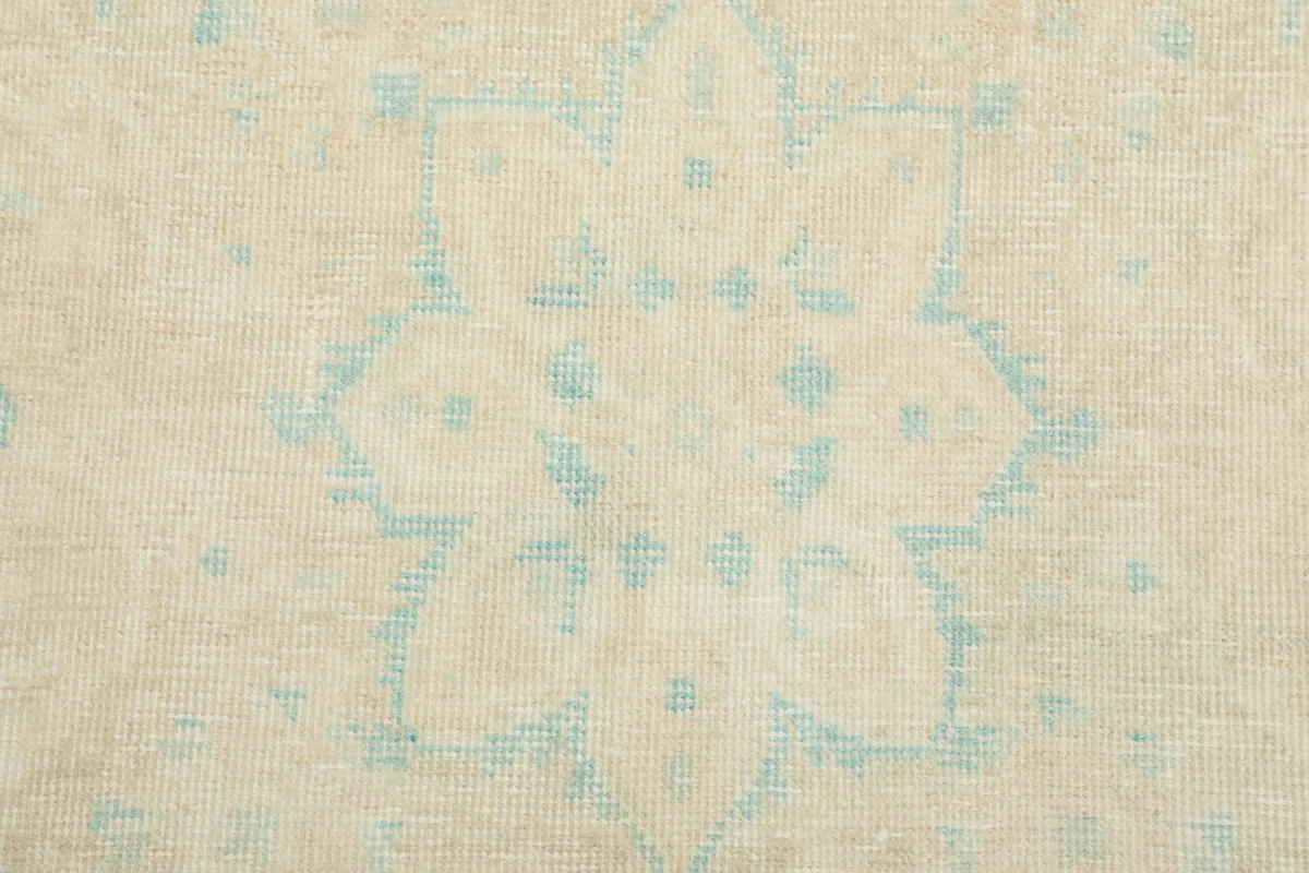Close-up showing the low pile texture and intricate hand-knotted wool construction.