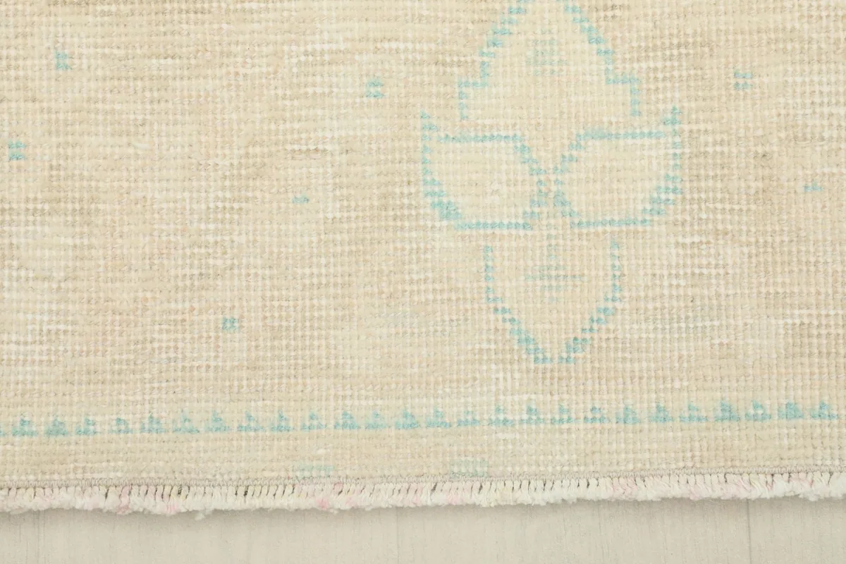Detail of the rug's edge, showcasing the short, natural fringe and border design.