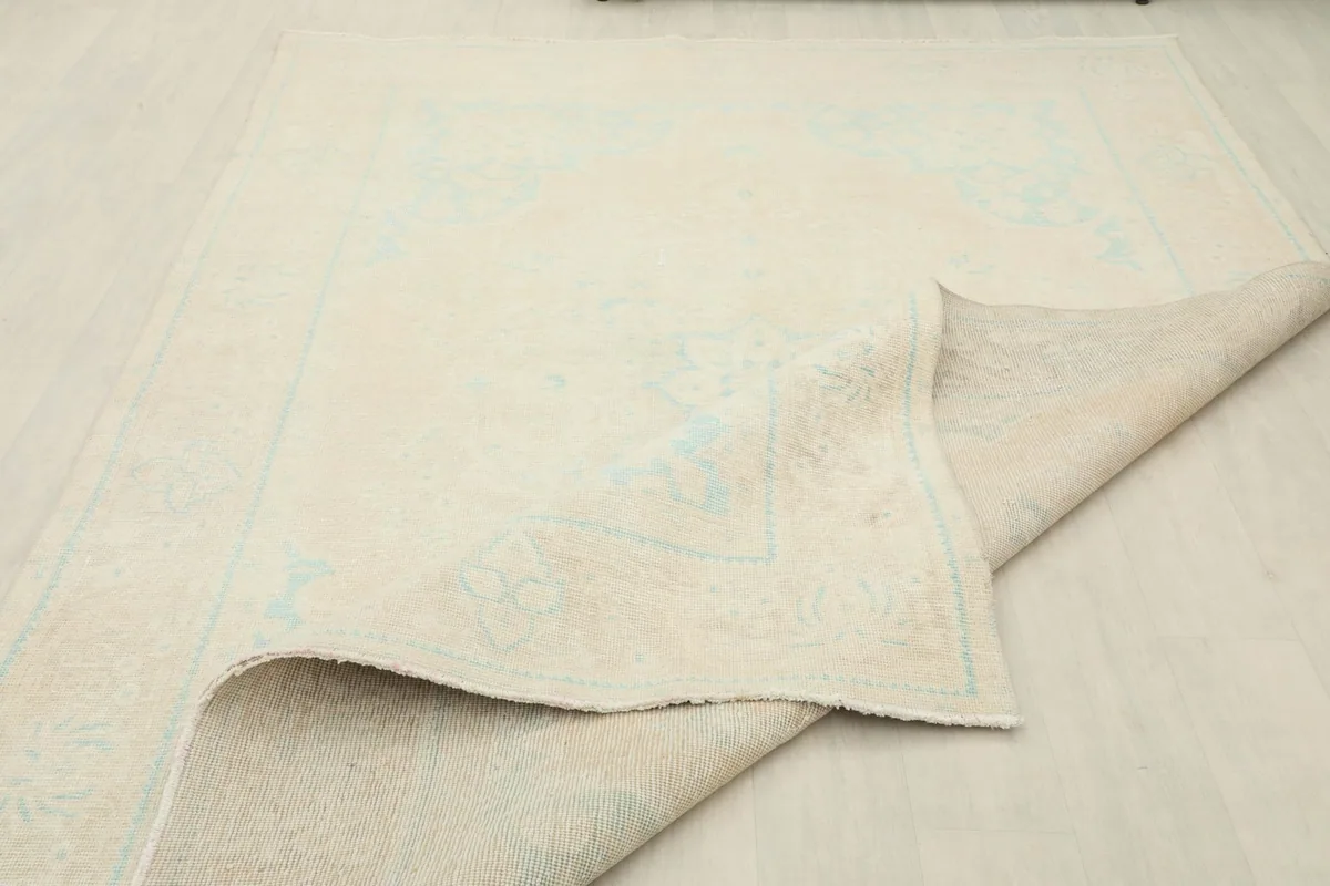 Rug partially folded, demonstrating its flexibility and the quality of its hand-knotted structure.