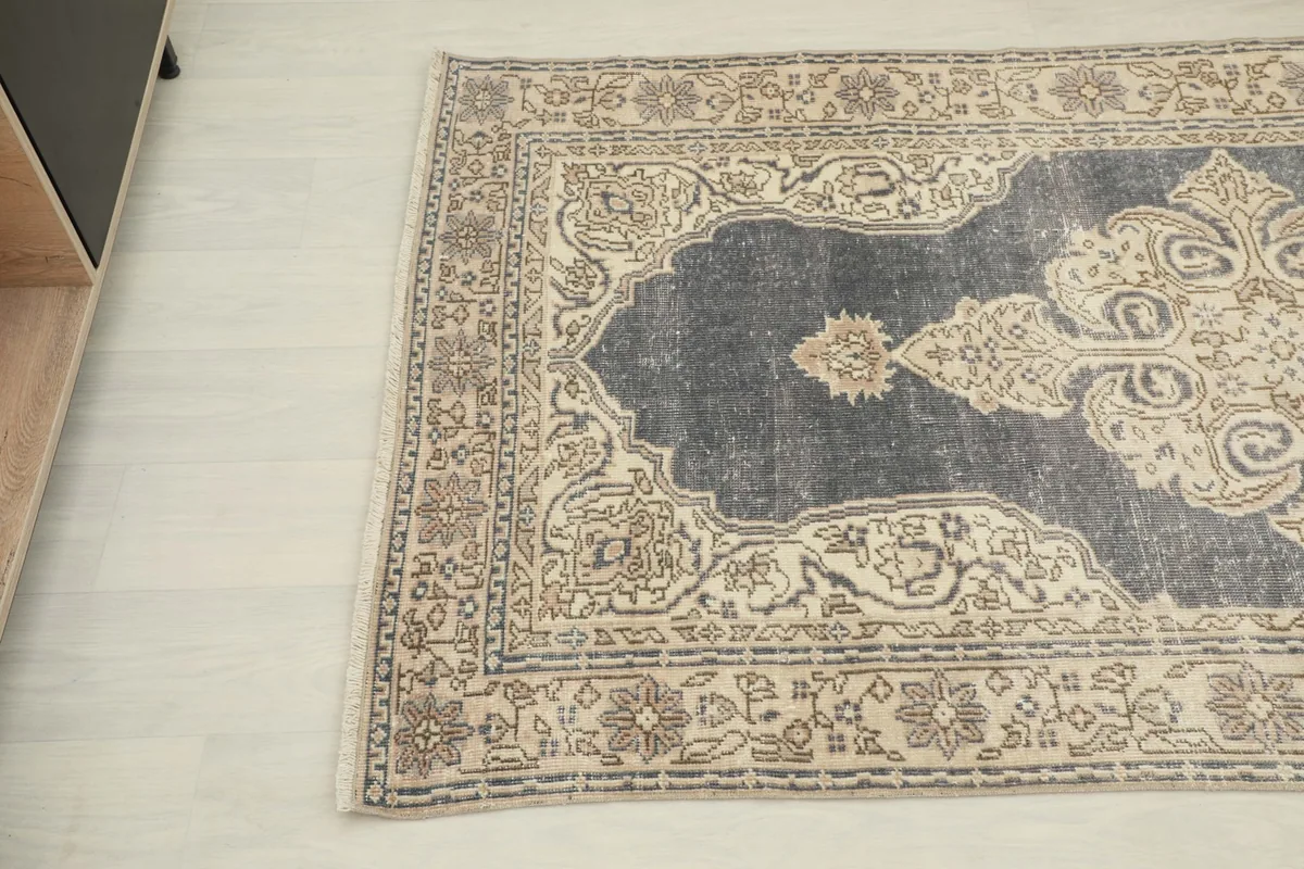 Angled view of the rug's top left corner, detailing the intricate patterns of the border and medallion.