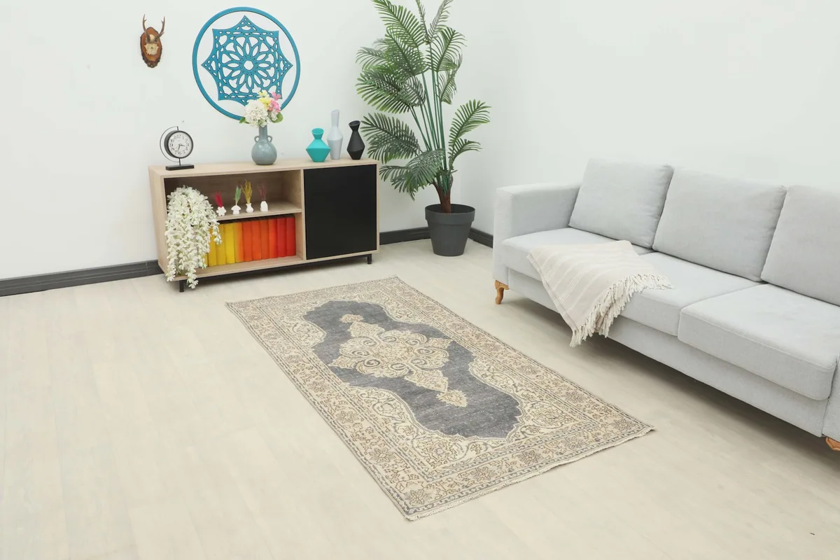 Vintage charcoal and ivory rug placed in a modern living room setting, showcasing its full length.
